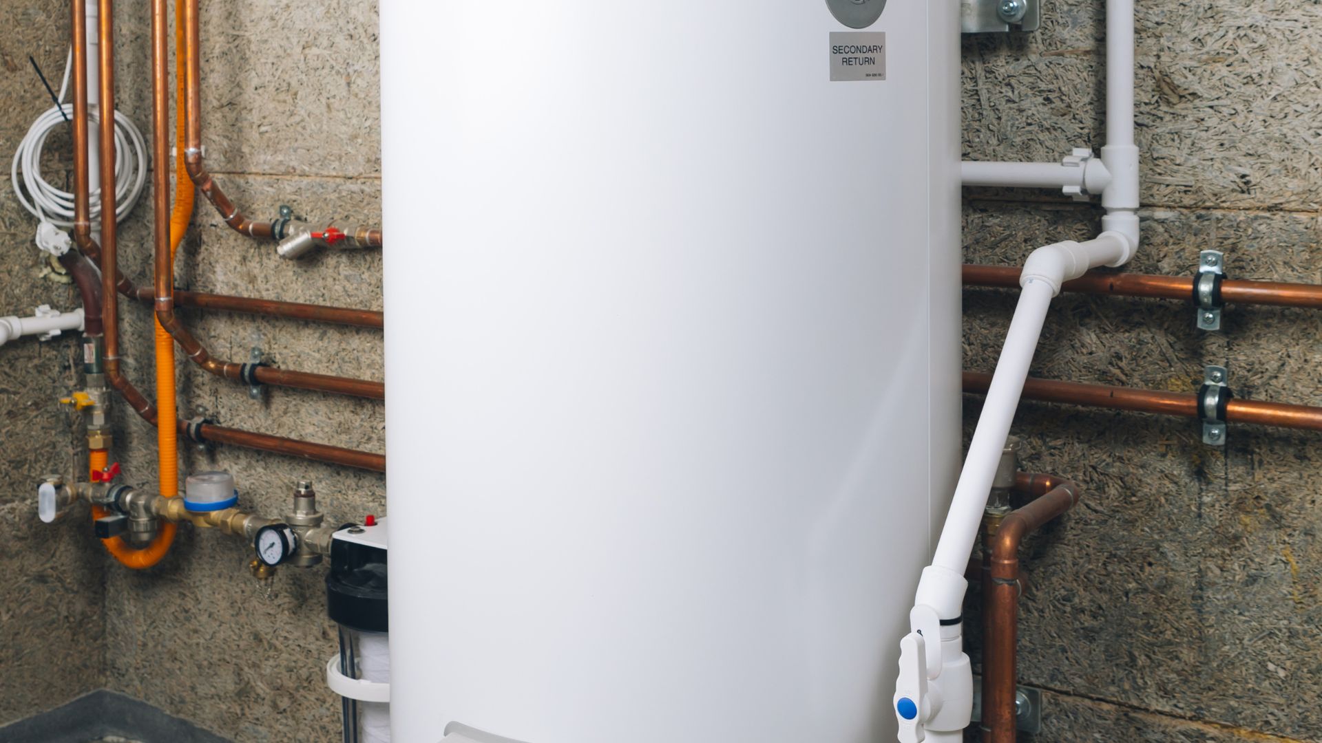 White water heater with copper pipes and valves in utility room