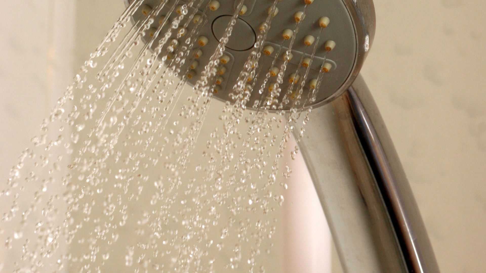 Close-up of water droplets flowing from a modern shower head