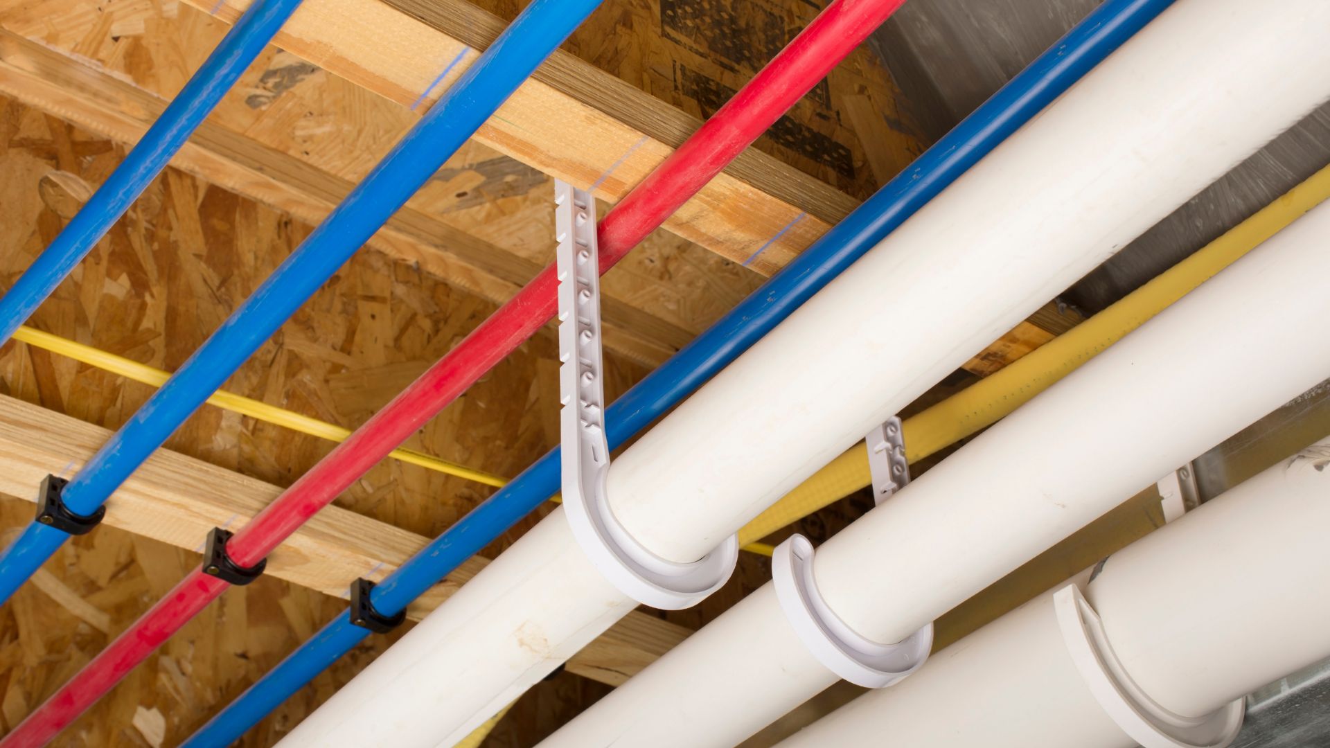 Colorful pipes and supports in wooden-framed ceiling of building