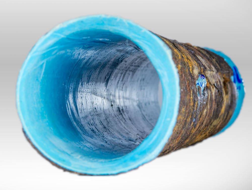 Rusty metal pipe with blue interior showing textured inner surface