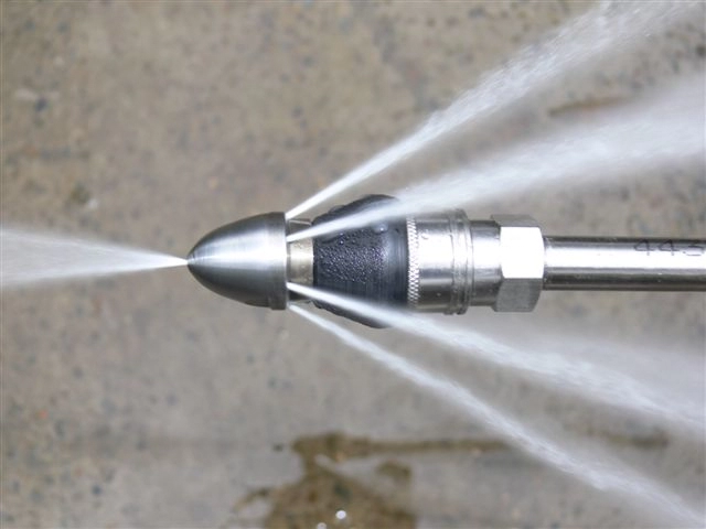 High-pressure water jet nozzle spraying water on concrete surface